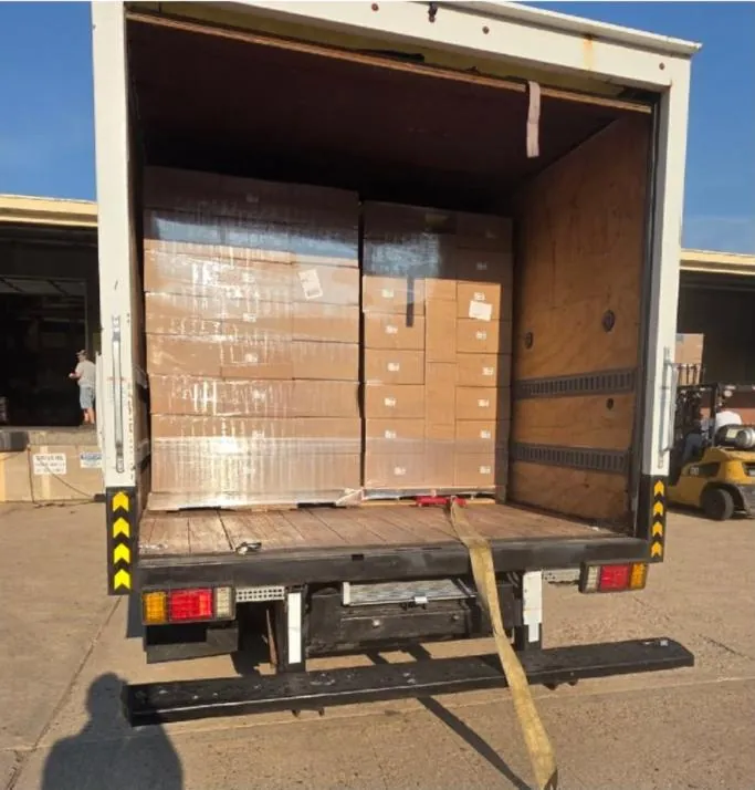 Truck backed up to a loading dock, loaded with pallets of cartons
